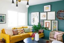 04 a colorful eclectic living room with a green statement wall with artworks, a boho rug, a mustard sofa and wicker touches