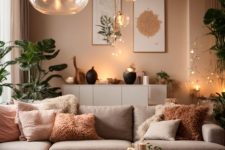 a lovely earthy living room with beige walls, a greige sofa with pillows, a low coffee table, a brown pouf and greenery