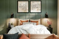 08 a lovely boho meets modern earthy bedroom with grene paneling, a bed with neutral bedding, a bench with pillows and sconces