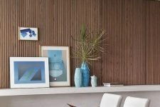 12 a beautiful ocean-inspired living room with a wood slat accent wall, neutral chairs, a low coffee table, some blue decor and textiles
