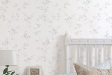a cute bedroom with a floral accent wall
