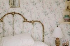 17 a shabby chic bedroom with delicate floral wallpaper, a shabby chic bed, floral bedding, a stool as a nightstand and a vintage lamp
