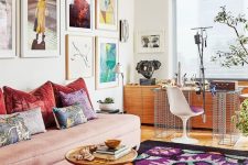 18 a bold maximalist living room with a blush sofa and colorful pillows, a bright rug, a desk, a storage unit and a colorful gallery wall
