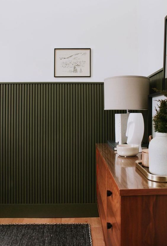 elegant dark green fluting accents everything that is in its backdrop and adds color and texture to the space