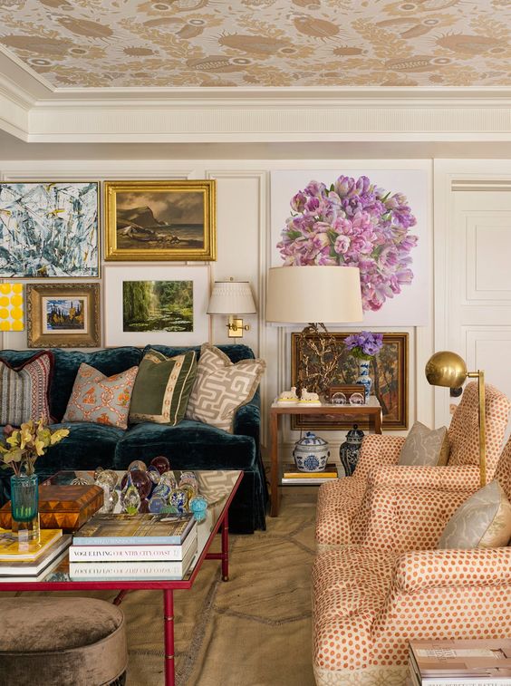 a bright maximalist living room with a dark green sofa and colorful pillows, polka dot chairs, a coffee table and a gallery wall
