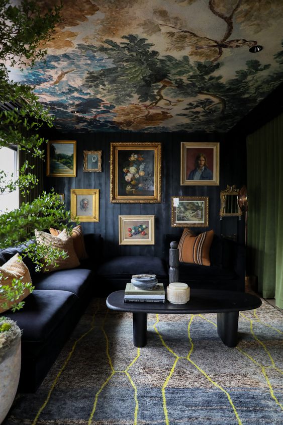 a bright eclectic living room with a soot wall, a green curtain, a bold ceiling, a printed rug, a navy sofa and a coffee table