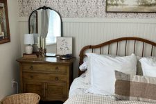 21 a lovely vintage cottage bedroom with floral wallpaper, paneling, a bed with printed bedding, a stained dresser, a basket and some art
