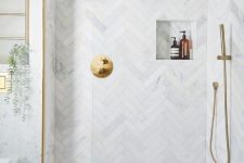 21 a neutral bathroom with penny and herringbone tiles, a niche, some brass touches and potted plants