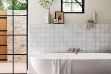 23 a farmhouse bathroom with neutral tiles, a terracotta tile floor, an oval tub, a glass door to the garden and neutral textiles