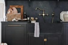 25 a black shaker style kitchen with black soapstone countertops and a backsplash, an open shelf to display beautiful vases