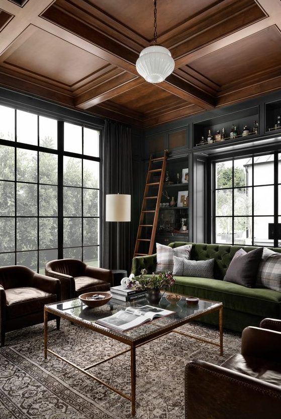 a refined graphite grey living room with a green sofa, brown leather chairs, pendant lamps and a coffee table