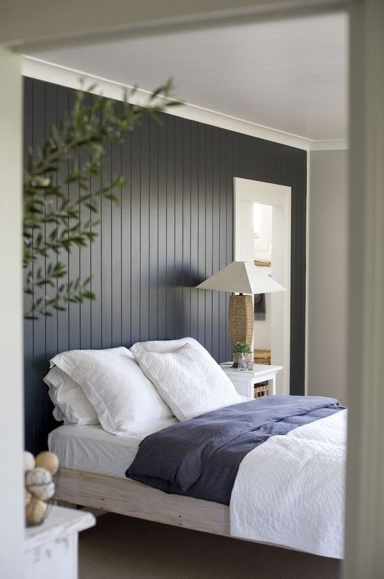 a black shiplap statement wall makes the bedroom more relaxed, cozy and ads a touch of drama with its color