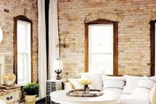37 a refined vintage living room with elegant furniture and whitewashed brick walls and a wooden ceiling for a vintage feel