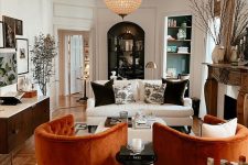 38 a bold living room with a fireplace and a wooden mantel, a white sofa, orange chairs, built-in shelves, a credenza and a statement phere lamp