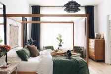 39 an eye-catchy bedroom with a stained canopy bed, green chairs, a stained dresser, nightstands, artwork and a black pendant lamp