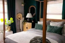 40 a small bold bedroom with a dark green accent wall and ceurtains, a canopy bed and neutral and green bedding and stripes poufs