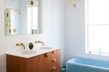 41 a mid-century modern bathroom clad with white square and blue hex tiles, a stained vanity, a blue bathtub