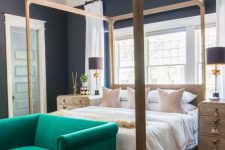 41 a moody bedroom with soot walls, a canopy bed and wooden nightstands, an emerald sofa, a beaded chandelier