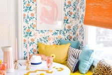 44 a bright breakfast book with bold floral wallpaper, a blue and yellow bench, a table, an orange shade
