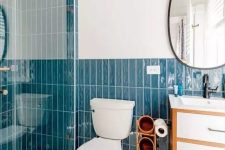 44 a catchy modern bathroom with bold blue stacked tiles, white hex tiles on the floor, a neutral vanity and white appliances