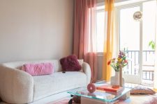 46 a dopamine-infused living room with a creamy sofa, a colorful rug and bold curtains, bright pillows and some blooms