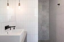 46 a minimalist bathroom done with grey tiles and white skinny ones for an eye-catchy touch