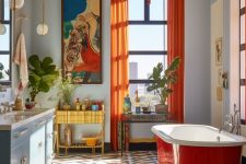 47 a dopamine-infused bathroom with blue walls, a bold floor, a blue vanity, a red bathtub and bold artwork