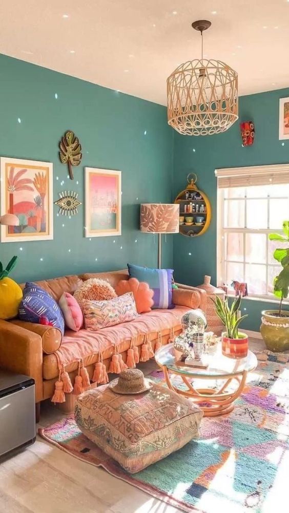 A colorful dopamine infused living room with green walls, an orange sofa and colorful pillows, a bright rug and some decor