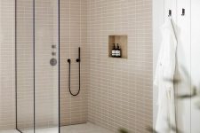 49 a neutral bathroom with planked walls and tan stacked tiles, a large shower space, black details for a contrast