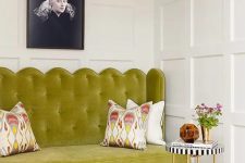 a beautiful English chic space with paneled walls, a chartreuse loveseat, a coffee table and printed pillows
