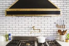 a beautiful vintage-inspired black and gold metal hood is a gorgeous idea to bring a touch of retro and color to the space