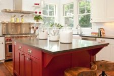 a beautiful vintage white kitchen with a red kitchen island, dark stone countertops and a metal cooker with a matching hood