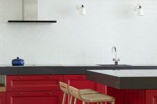 a bold and contrasting kitchen with lower red cabinets and statement countertops, a white tile backsplash and pendant lamps