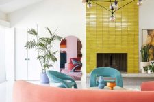a bold living room with a fireplace clad with chartreuse stacked tiles, blue chairs, a coral rounded sofa and potted plants