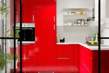 a bright red kitchen with open shelves and stone countertops and a whole vertical wall garden is a cool space