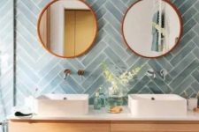 a chic bathroom with blue herringbone tiles, a stained vanity, mirrors and sinks is a lovely space