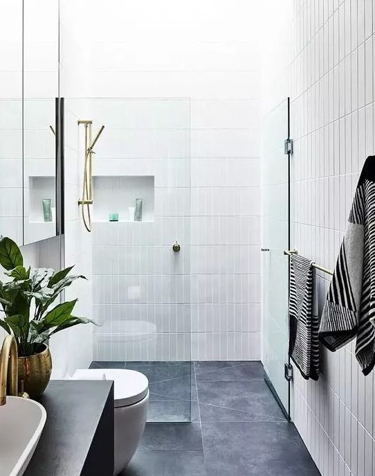 a chic contemporary bathroom with grey tiles on the floor and white skinny tiles on the walls plus niches
