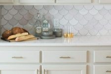 a chic neutral kitchen with a marble fishscale tile backsplash that make it interesting and catchy at once