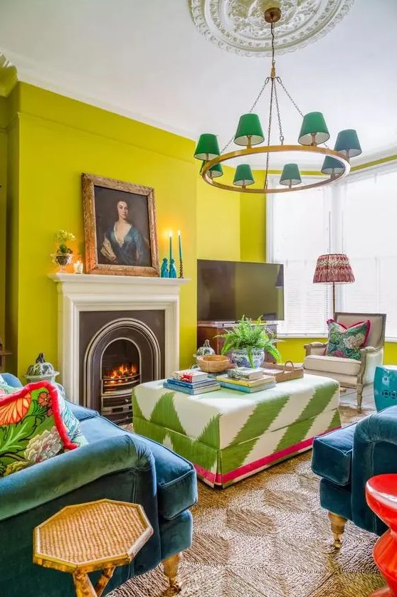 a colorful and eclectic living room with chartreuse walls, a fireplace, a bold printed ottoman, navy chairs and a sofa, a catchy chandelier