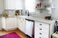 a contemporary white kitchen with stone countertops and white skinny tiles highlighted with black grout looks very nice