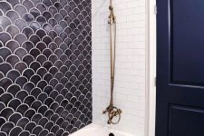 a contrasting bathroom done with white subway, penny and midnight blue scallop tiles that match the door