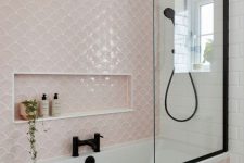a delicate and cute bathroom done with white subway and blush fishscale tiles, black fixtures for a more modern look