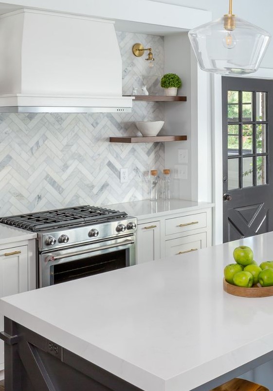 a farmhouse kitchen in graphite grey and white, with gold touches, wooden shelves and a catchy marble tile backsplash