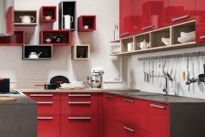 a glossy red kitchen with grey countertops, a white backsplash and eye-catchy colorful box shelves