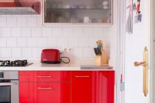a hot red kitchen with white square tiles, stainless steel appliances and red ones is a lovely and catchy space