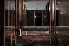 a jaw-dropping chocolate brown marble bathroom with a large mirror, a black soak tub and a shower space