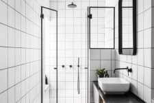 a laconic black and white bathroom with square white tiles and herringbone tiles on the floor, a black floating vanity and black fixtures