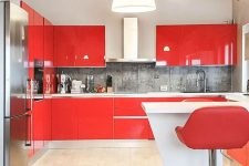 a large attic kitchen with glossy red cabinets, a grey stone backsplash, white countertops, a white kitchen island