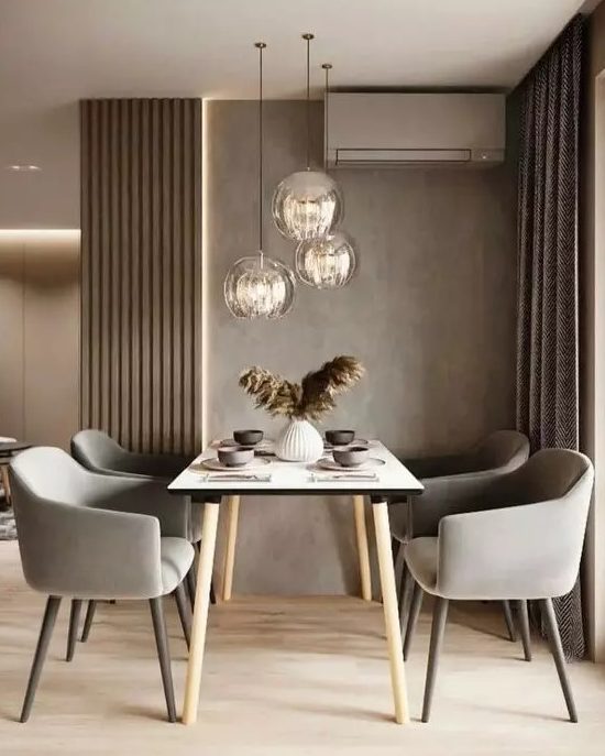 a lovely and welcoming taupe dining zone with taupe walls, paneling and curtains, a simple table and grey chairs plus pendant lamps