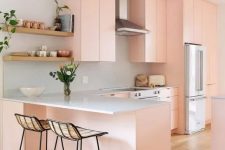 a lovely peachy pink flat panel kitchen with white granite countertops, tall woven stools and open shelving is amazing
